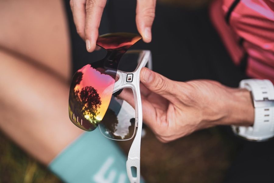 Eine Frau vergleicht zwei Sportbrillen miteinander.